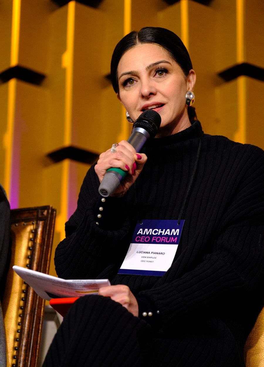 Luciana Pianaro falando ao microfone em um evento